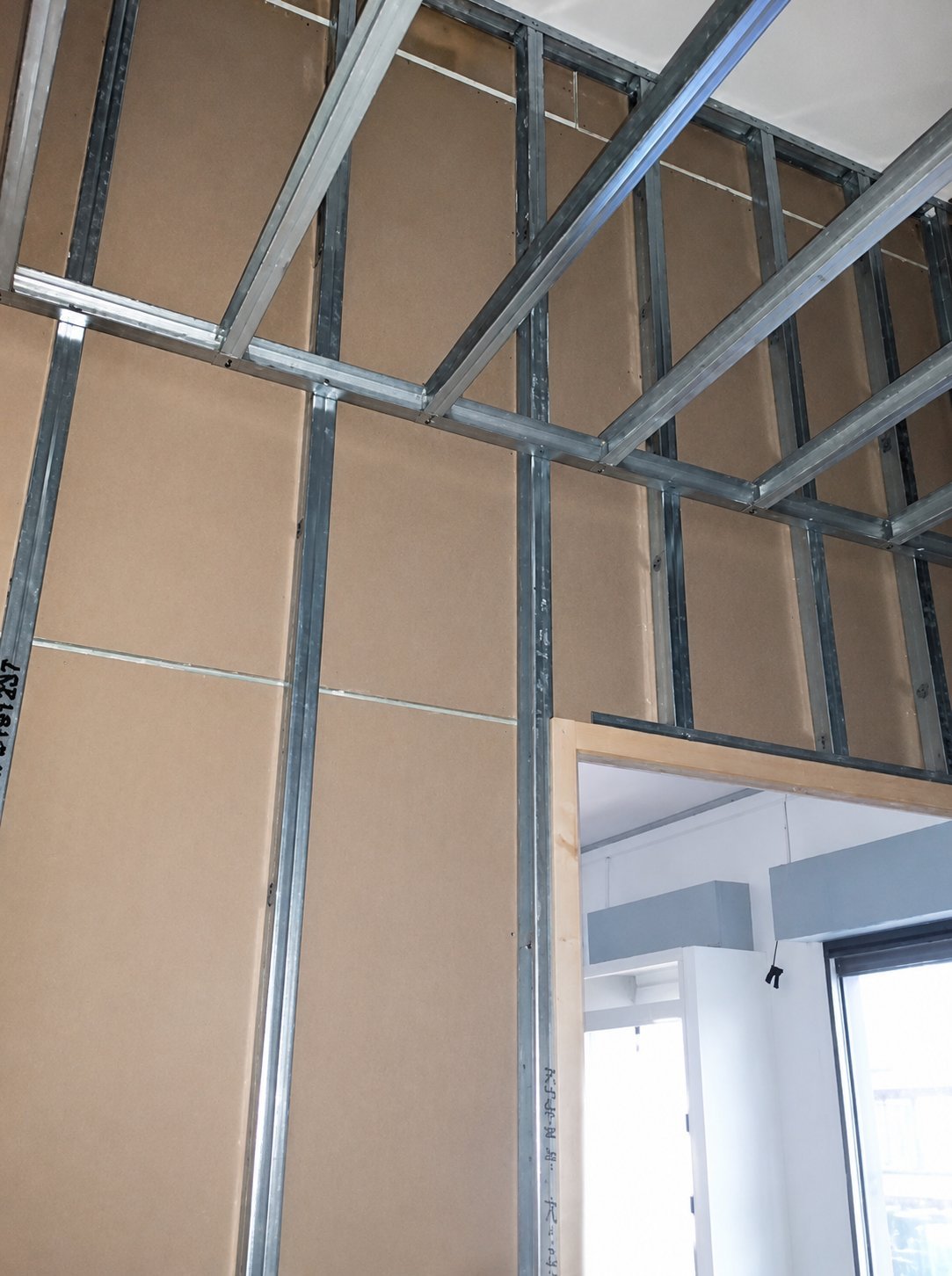 Trockenbau-Innenansicht mit Metallständerwerk und Profilen an Wänden und Decke eines unfertigen Raums
