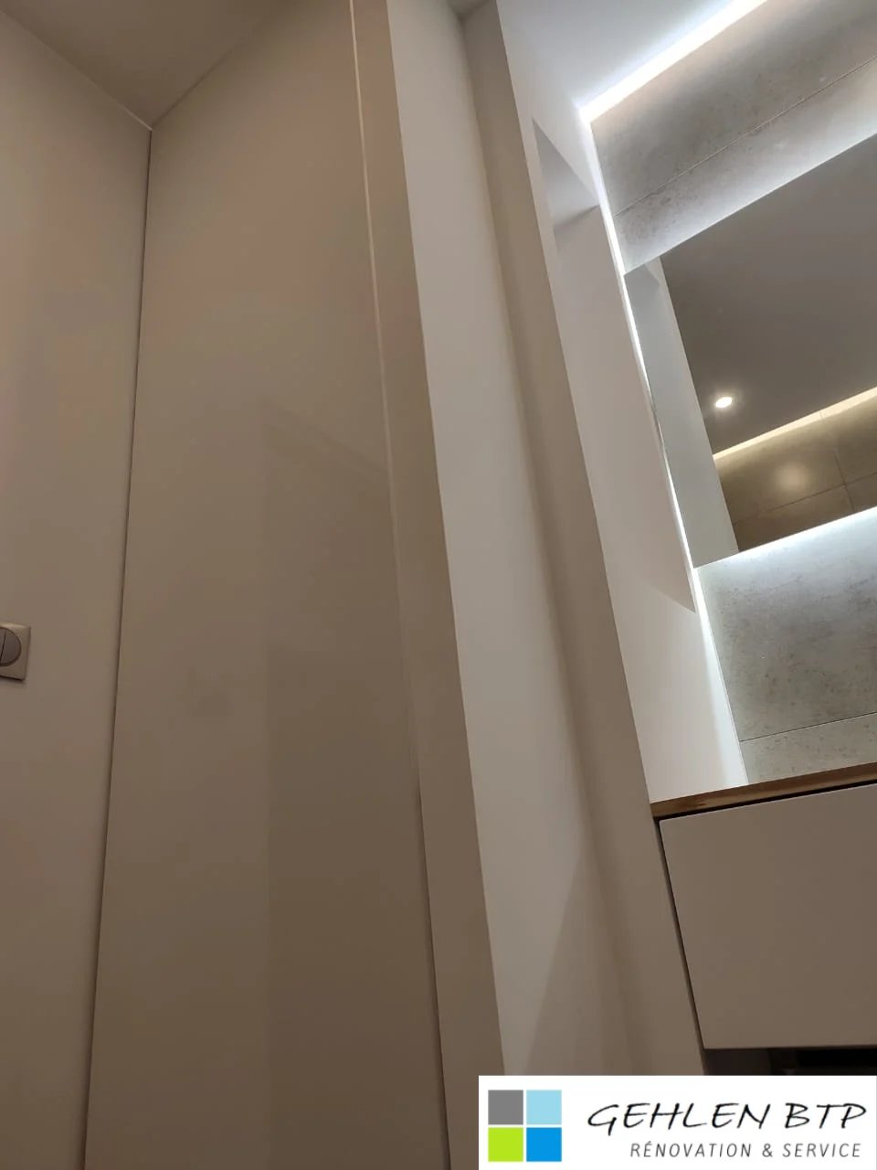 Modern bathroom interior with white walls, recessed LED lighting strips, and minimalist design elements