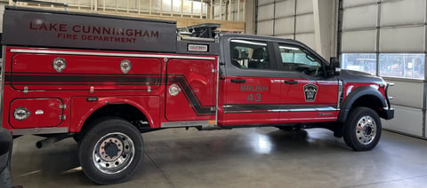 Red Lake Cunningham Fire Department pickup truck with utility bed parked inside a fire station garage