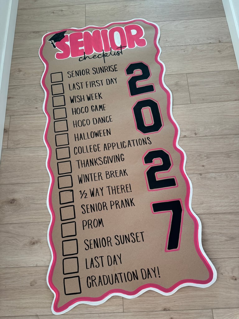 Pink senior checklist poster on wooden floor with checkboxes for 2027 graduation events and milestones