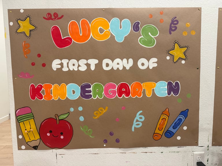 Poster with colorful letter cutouts reading Lucys First Day of Kindergarten decorated with stars, pencils, apple, and confetti on brown cardstock