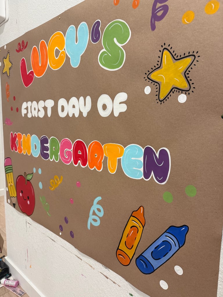 Colorful poster reading HELLOS FIRST DAY OF KINDERGARTEN with hand-drawn decorations including stars, crayons, and an apple