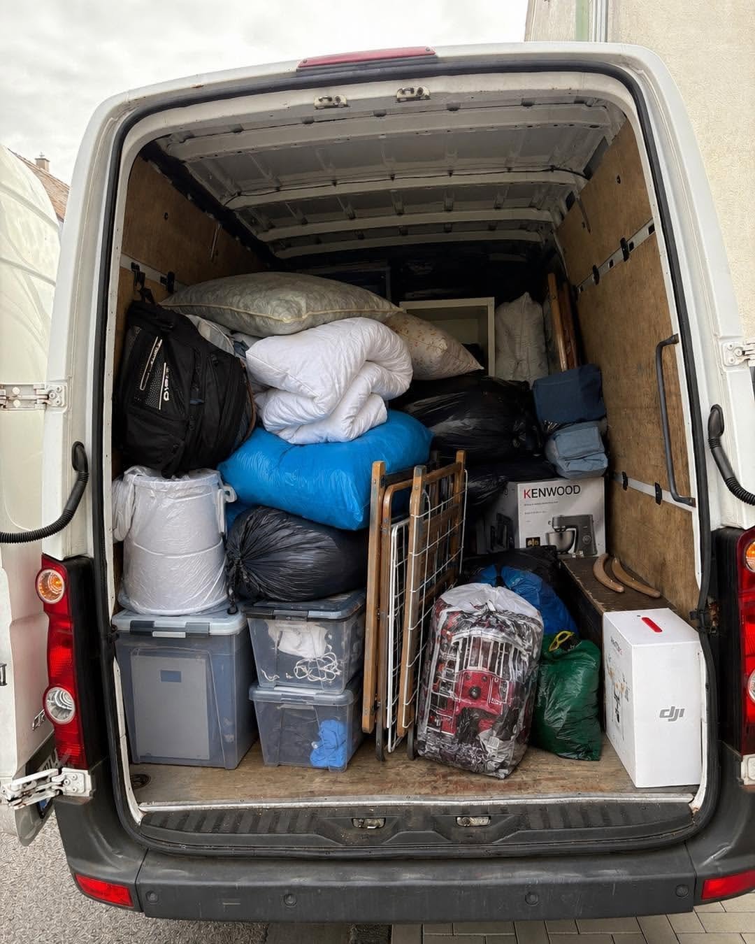 Fully loaded moving van interior packed with furniture, boxes, and household items ready for relocation