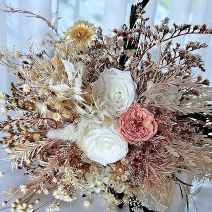 Dried flower bouquet with white roses, blush pink rose, and brown dried grasses and foliage arrangement