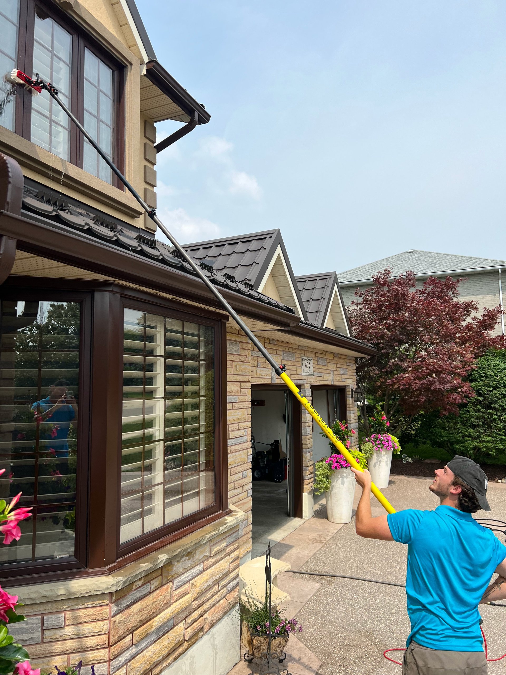 Home Hygiene technician cleaning a brick home exterior