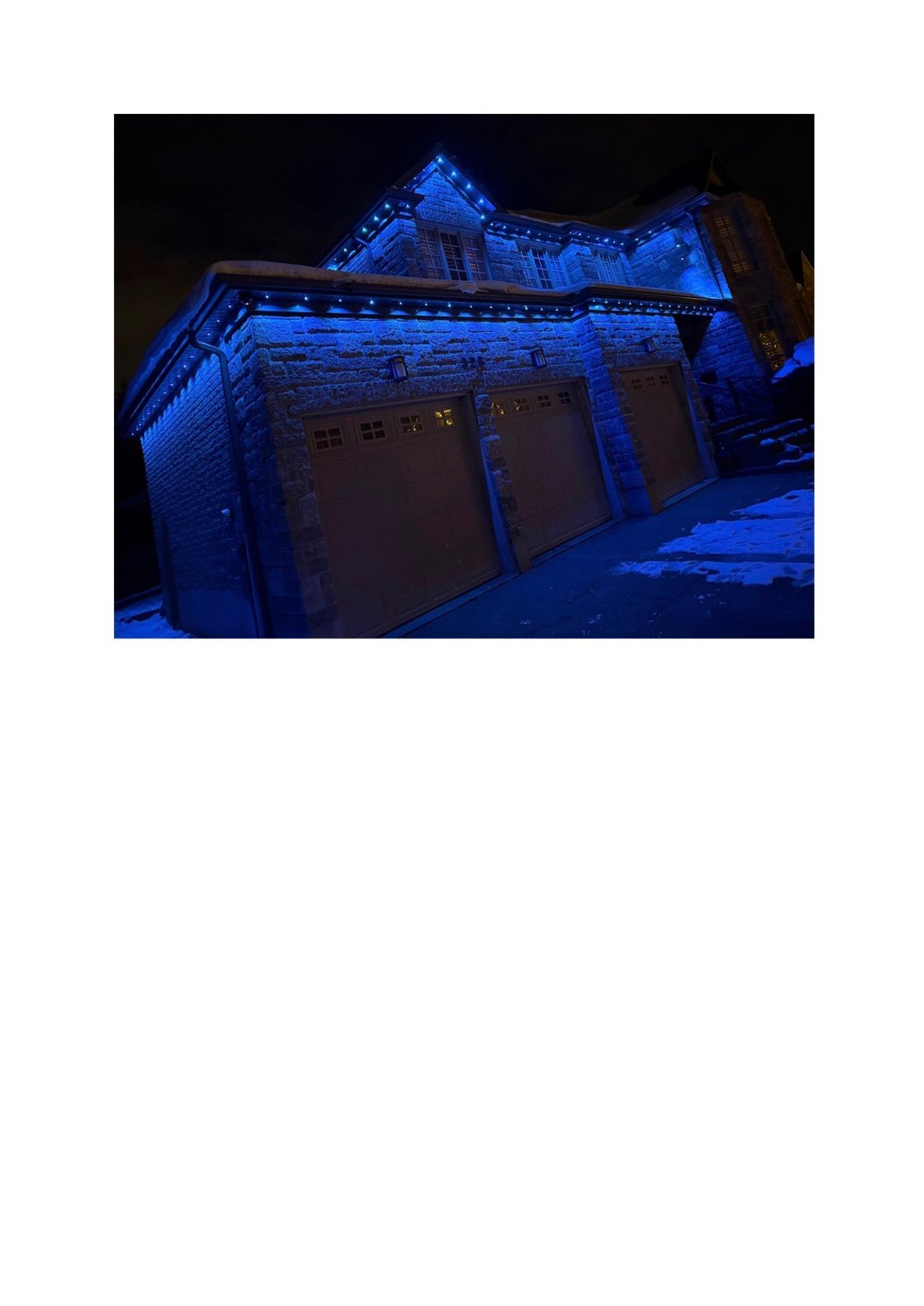 Historic building illuminated with blue LED lights at night, showcasing ornate architecture and illuminated windows