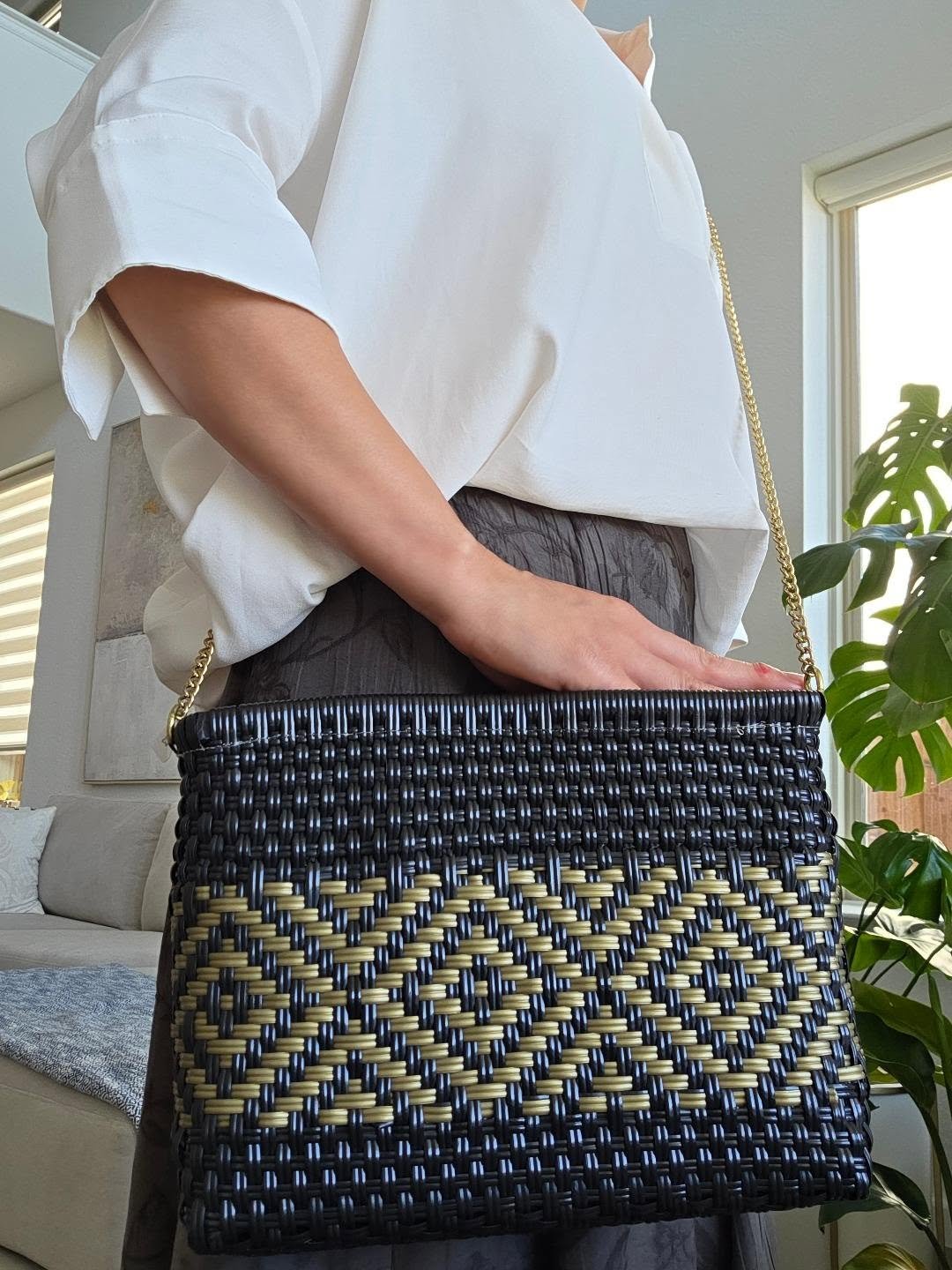 Bolso crossbody tejido en negro y dorado con patrones geométricos