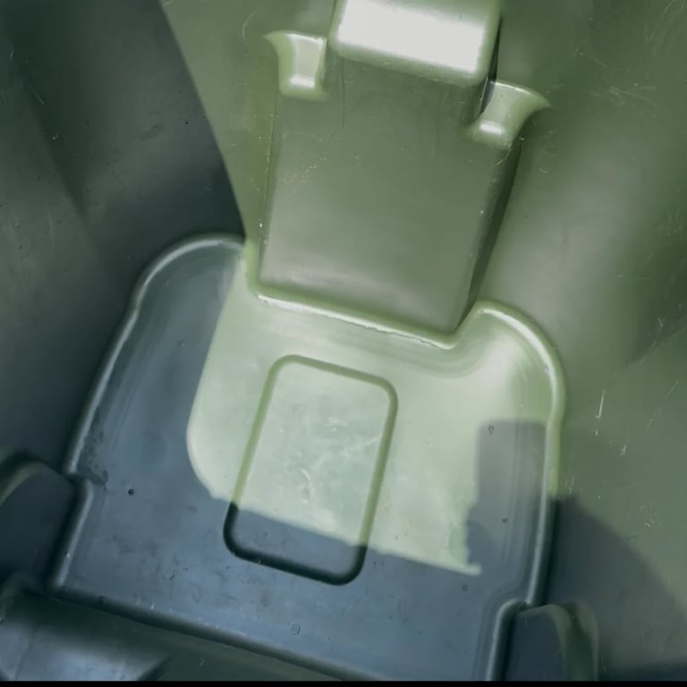 Clean green and gray trash can interior after professional cleaning, looking fresh and sanitized