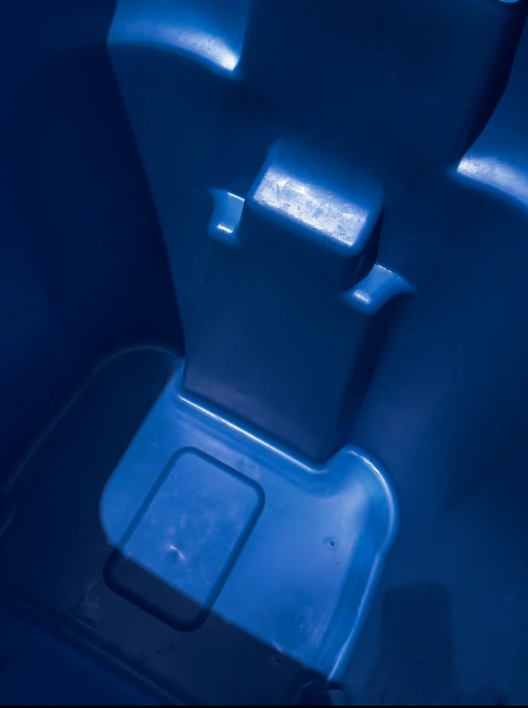 Clean blue trash can interior with the lid open, showing freshly cleaned plastic surfaces and compartments