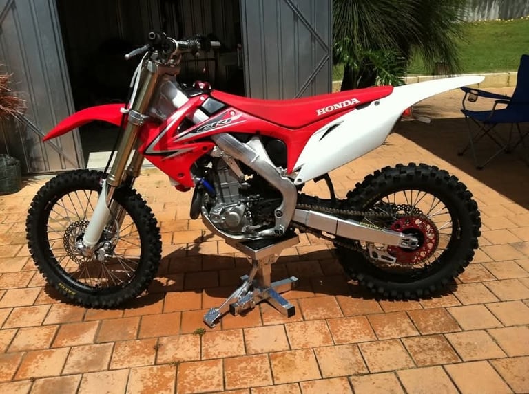 Dirt bike on a stand in a garage driveway