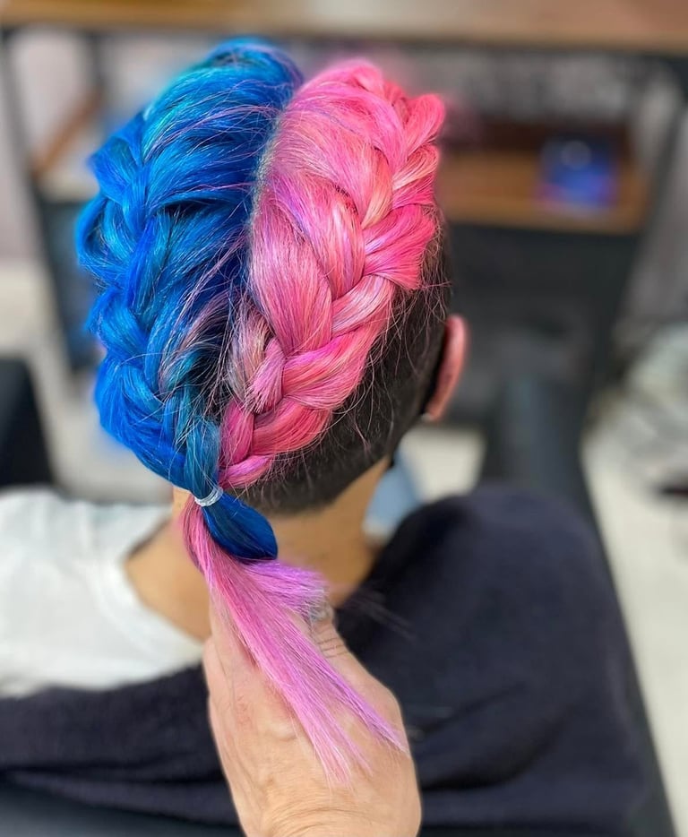 Back view of a person with a split-dyed braid hairstyle in bright blue and hot pink colors
