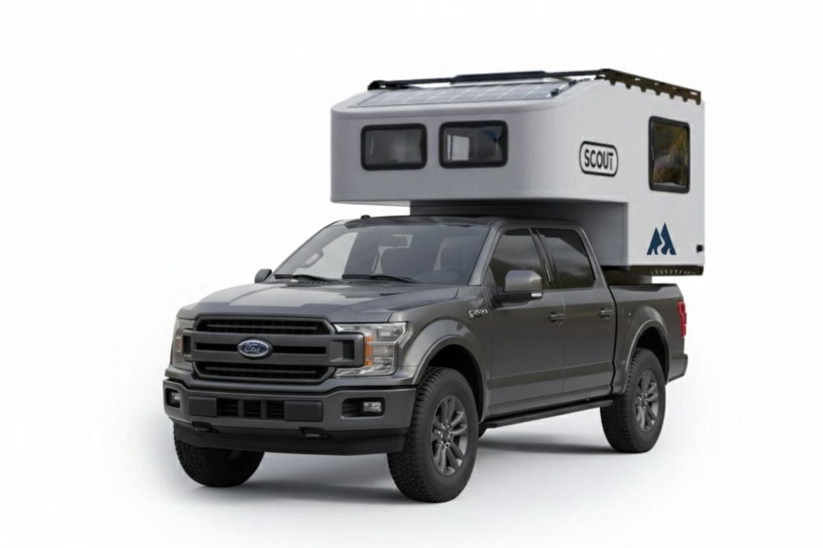 Gray Ford pickup truck with white camper shell mounted on the bed against white background