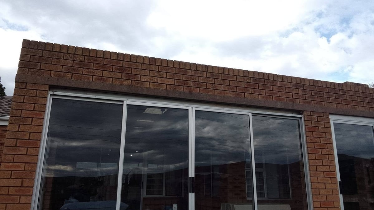 Row of large black-framed windows in a red brick building exterior wall