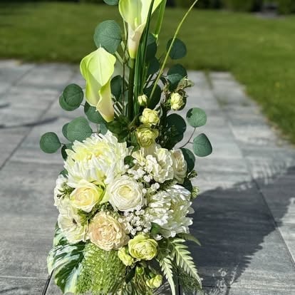 Elegancka kompozycja z białych róż, zielonych hortensji, eukaliptusa i zieleni w wysokim wazonie na tarasie