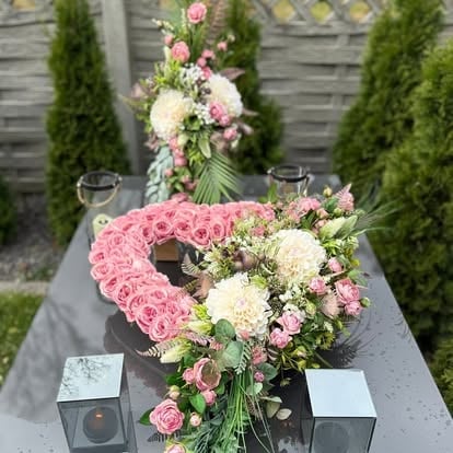 Elegancka kompozycja z różowych i białych kwiatów w szklanych wazonach na stole