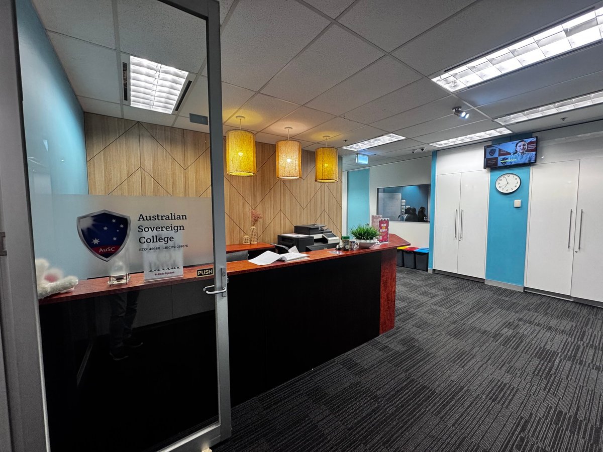 Video intercom and security access point at a glass-door entry in a modern Melbourne office reception with blue pendant lights