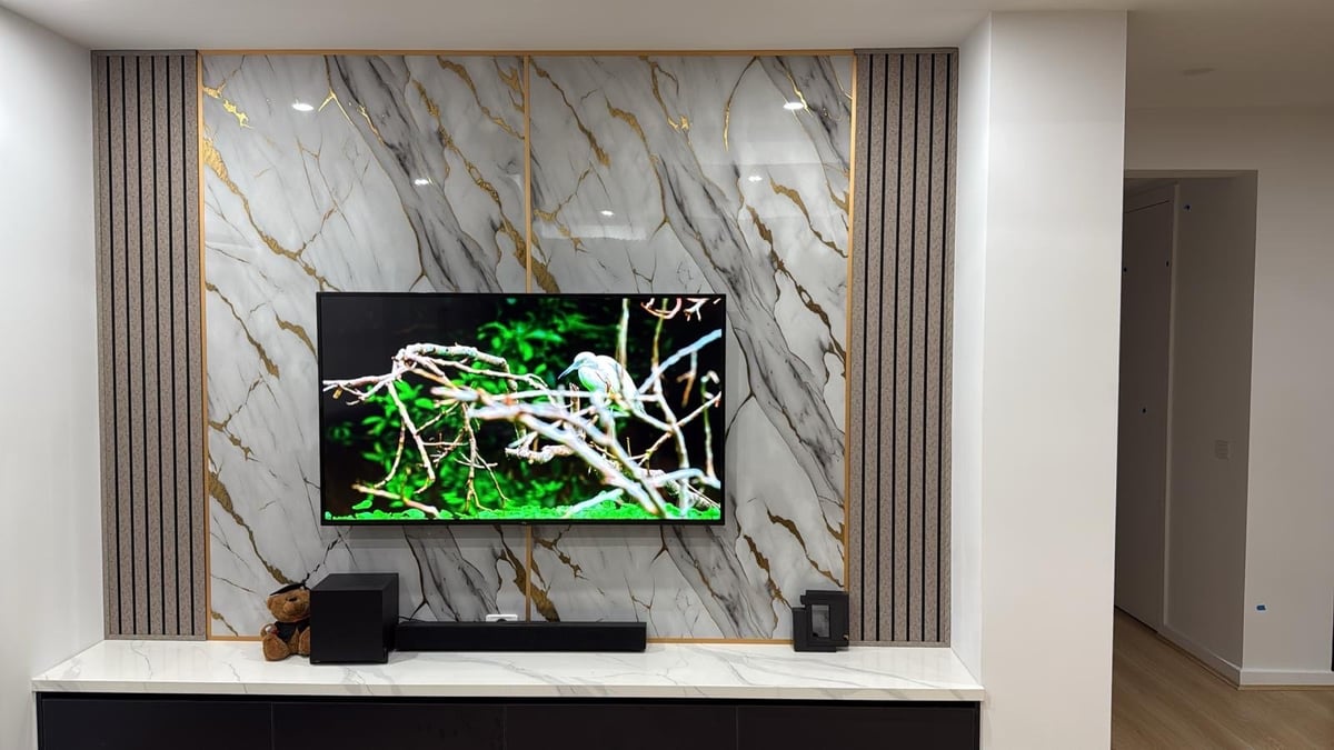 Professionally wall-mounted flat-screen TV with concealed cables on a marble accent wall in a Melbourne living room