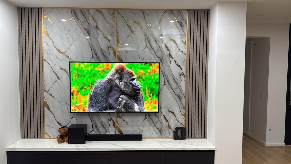 Wall-mounted TV with digital TV antenna connection in a modern Melbourne living room with marble accent wall and floating media console