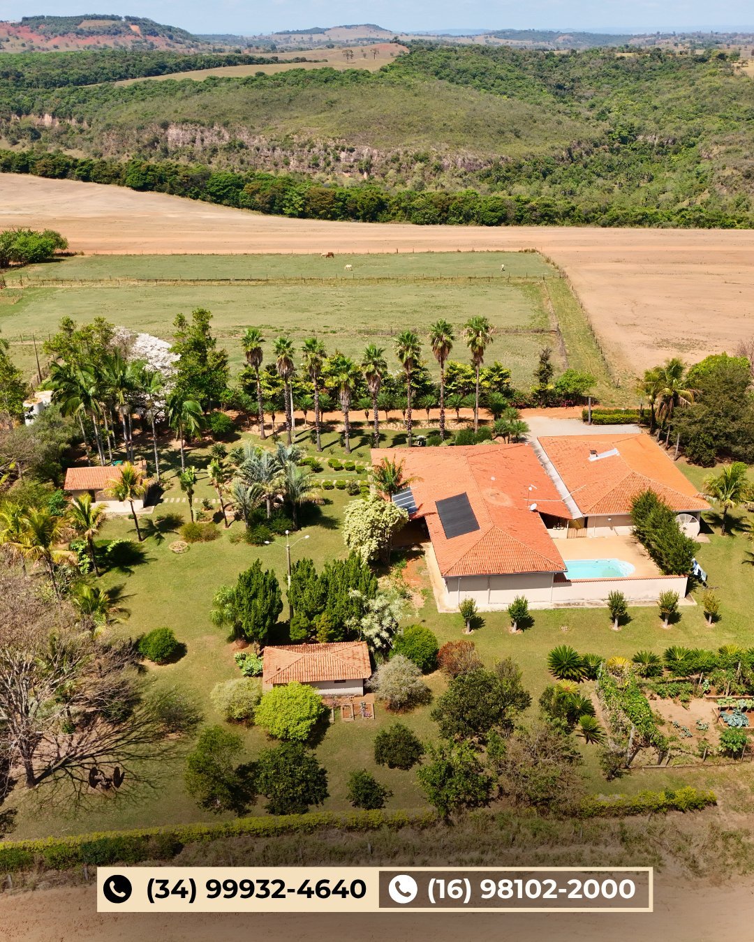 Vista aérea de propriedade rural com telhado laranja, palmeiras e campos agrícolas ao redor