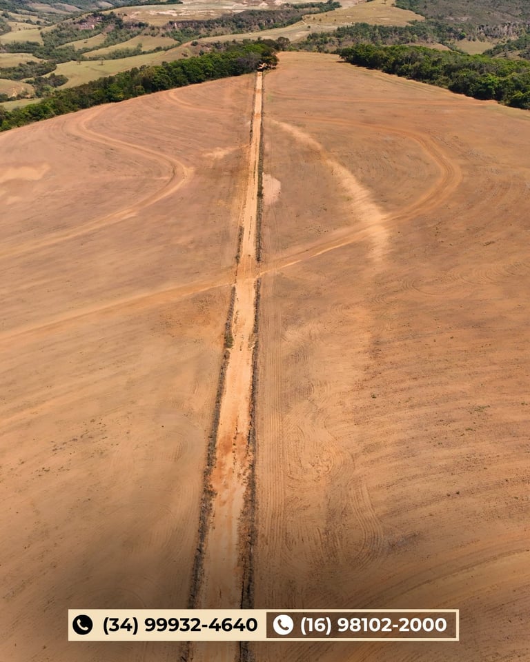 Vista aérea de trator arando um grande campo curvo de solo marrom