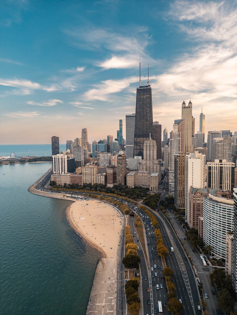 Aerial view of Chicago skyline with Lake Michigan, sandy beach, and downtown buildings under blue sky