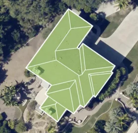 Aerial view of a house with green lawn divided into geometric sections by white pathways and landscaping lines