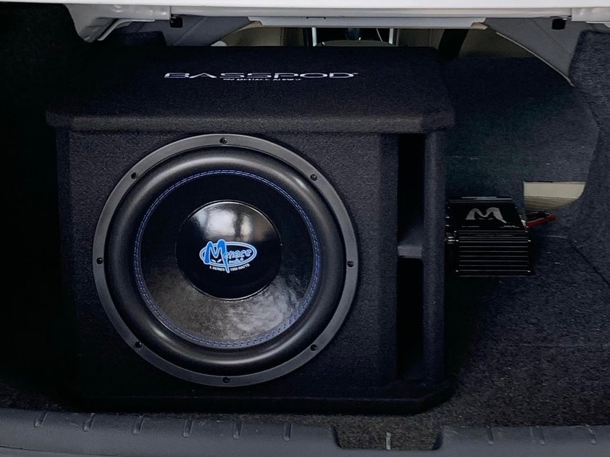 Car subwoofer speaker with blue logo in black enclosure mounted in vehicle trunk