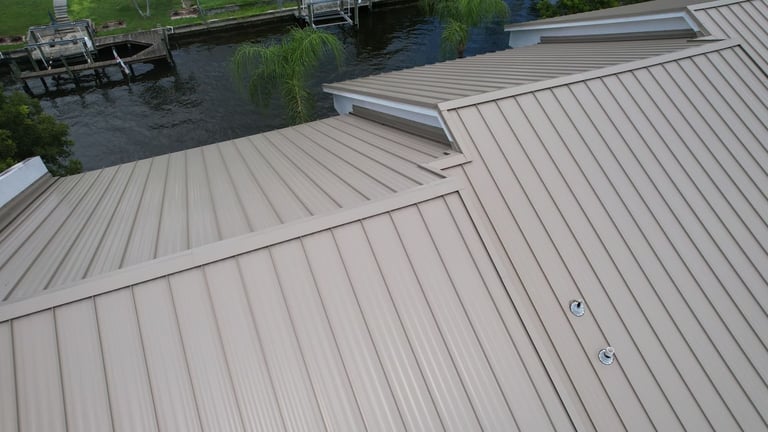 Tan standing seam metal roof hips and valleys on a commercial building near a canal in Cape Coral, FL