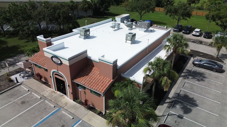 Aerial view of Tamiami Tavern restaurant with a new bright white commercial flat roof and clay tile accent roofs