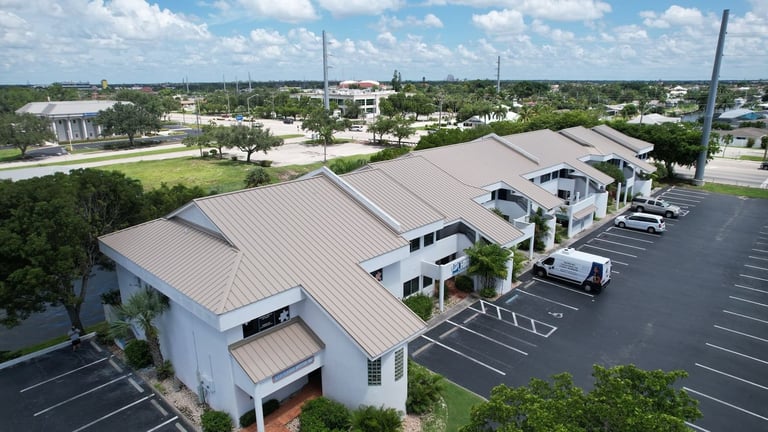 Tan standing seam metal roof on a two-story commercial office and retail building in Cape Coral, FL