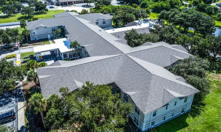 Drone view of hip and valley shingle roof replacement on a two-story assisted living building