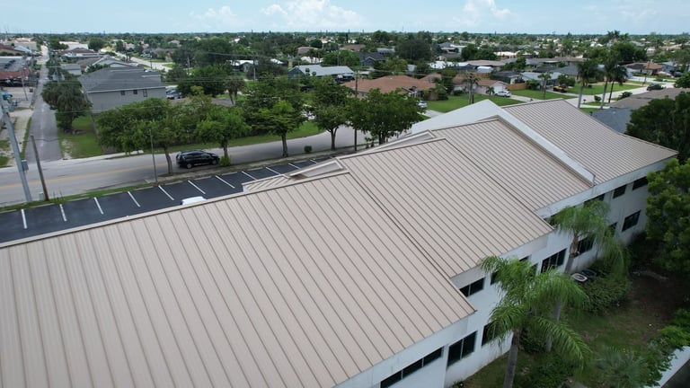 Standing seam metal roof planes on a commercial building with a residential neighborhood behind, Cape Coral, FL