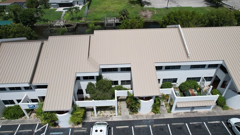 Front aerial of a commercial building's new standing seam metal roof with gables and balconies in Cape Coral, FL
