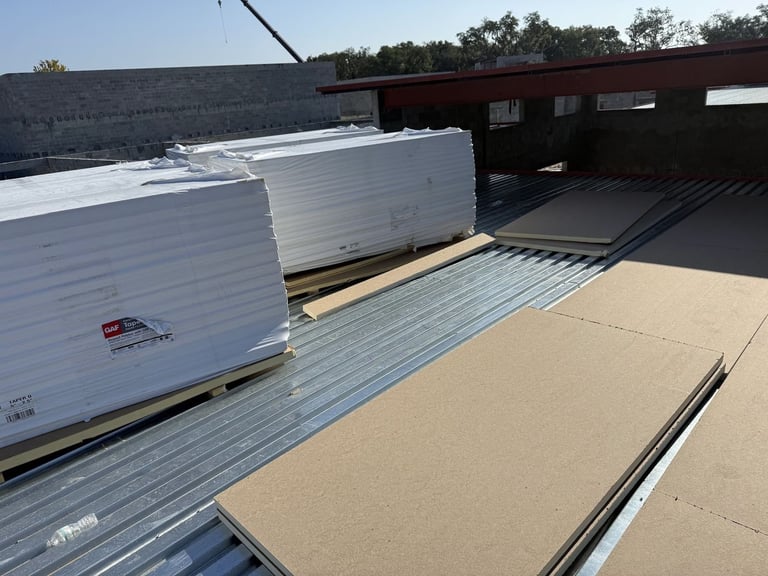 GAF tapered polyiso insulation boards staged on a corrugated metal roof deck for a commercial flat roof