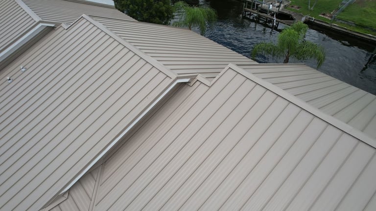 New tan standing seam metal panels meeting at a valley on a waterfront commercial building in Cape Coral, FL