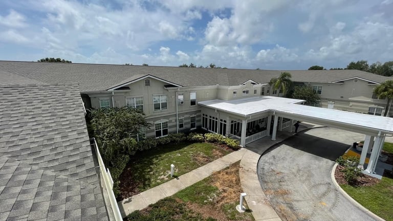 Rooftop view of a new architectural shingle roof above the courtyard and entrance canopy of a care facility