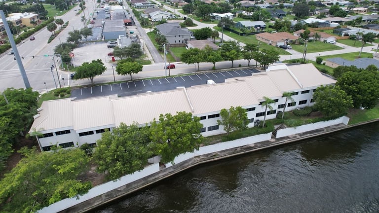 Waterfront commercial building with a tile-to-standing seam metal roof conversion along a canal in Cape Coral, FL
