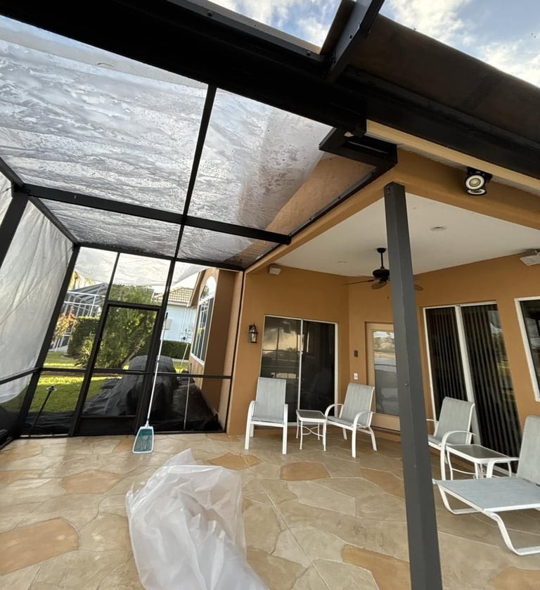 Screened lanai with plastic sheeting over the screen roof and patio area to catch roofing debris
