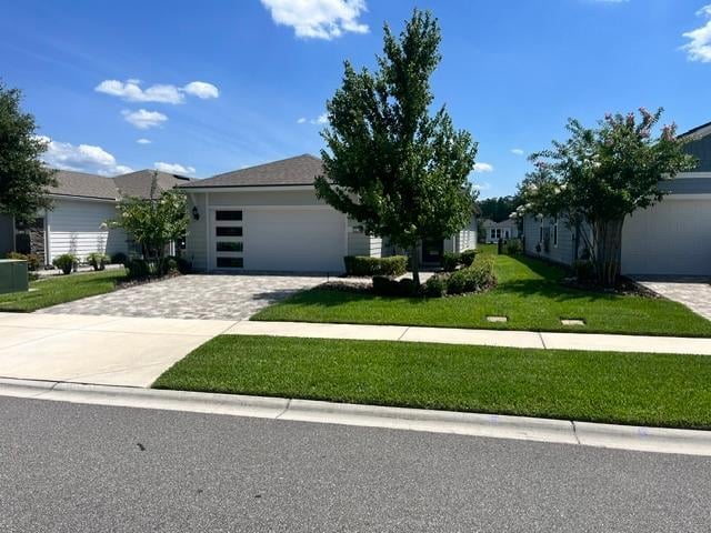 Modern suburban home with gray garage door, manicured lawn, and landscaping trees on a residential street