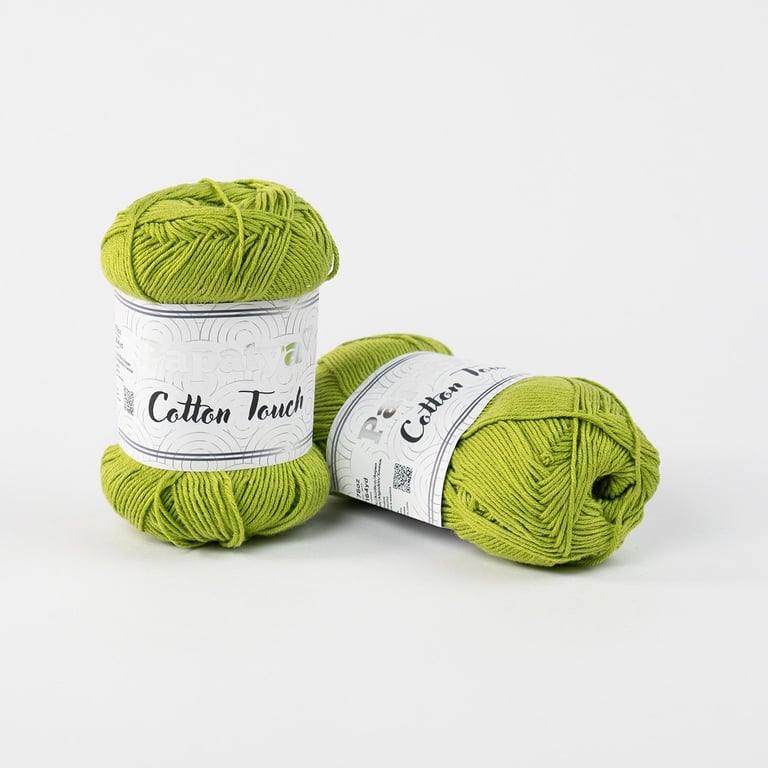 Three skeins of bright green Cotton Touch yarn with white labels on a light gray background