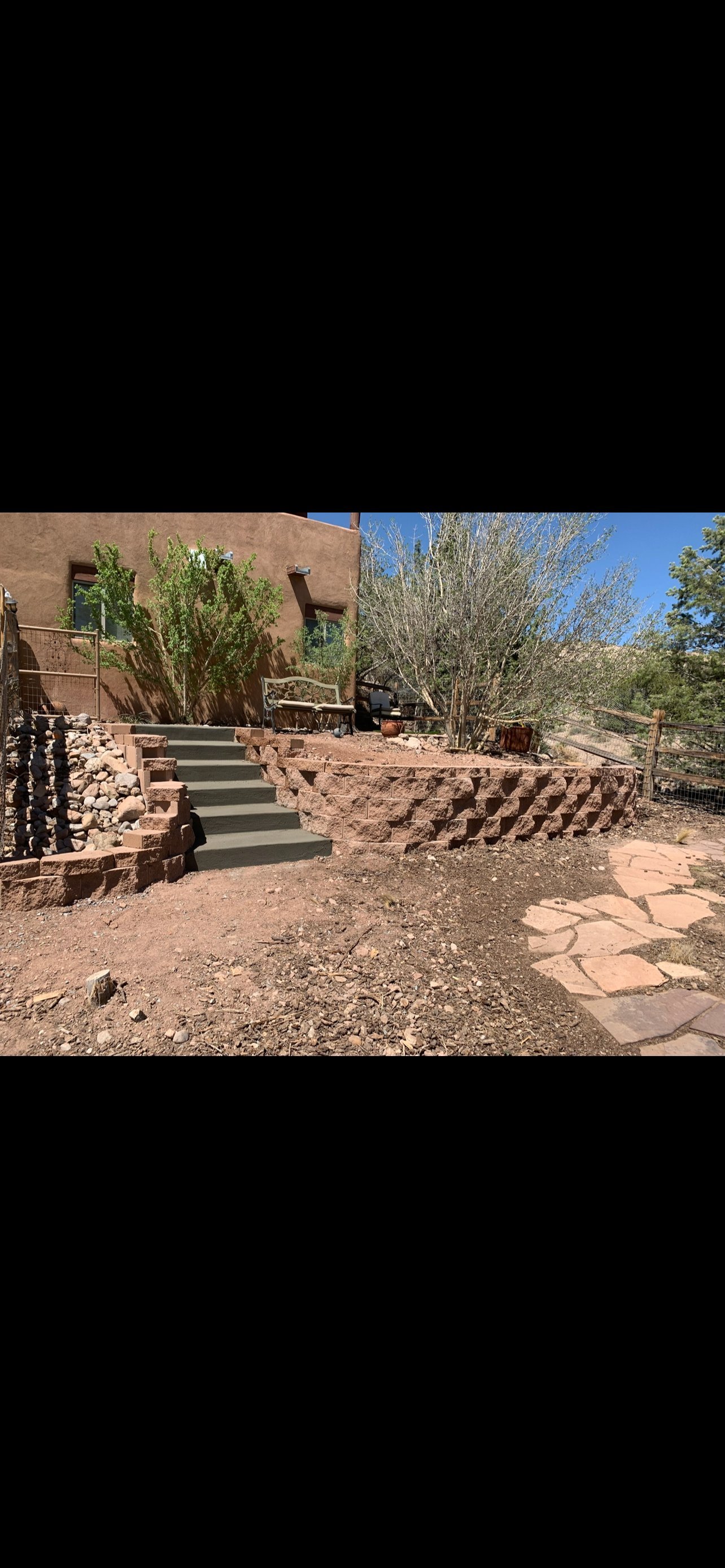 Adobe building with terraced garden steps in an arid southwestern landscape