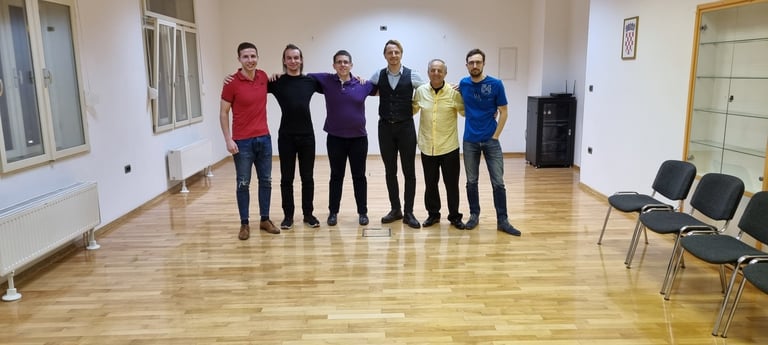 Osam polaznika stoji u redu na drvenom podu svijetle dvorane Plesne škole Banderillas Zagreb