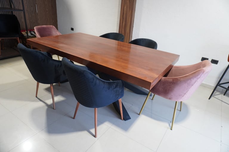 Modern dining room with a wooden table and mismatched upholstered chairs in blue and pink fabrics