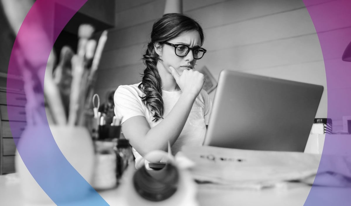 Woman wearing glasses sitting at desk with laptop, hand on chin in thoughtful pose, black and white photo with purple and blue design elements