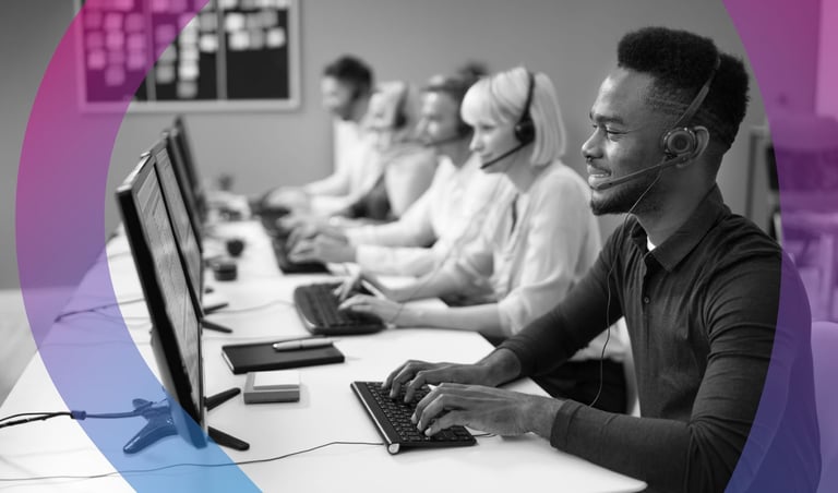 Customer service representatives in headsets working at desks with computers in a modern office environment