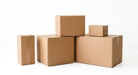 Stack of various sized brown cardboard shipping boxes arranged in a pyramid formation on white background