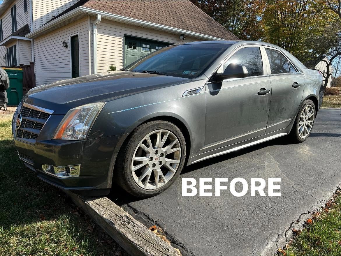 Silver Cadillac CTS sedan with a dusty exterior in a driveway before detailing work