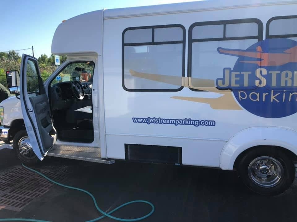 White Jet Stream parking shuttle van with the driver-side door open after being detailed