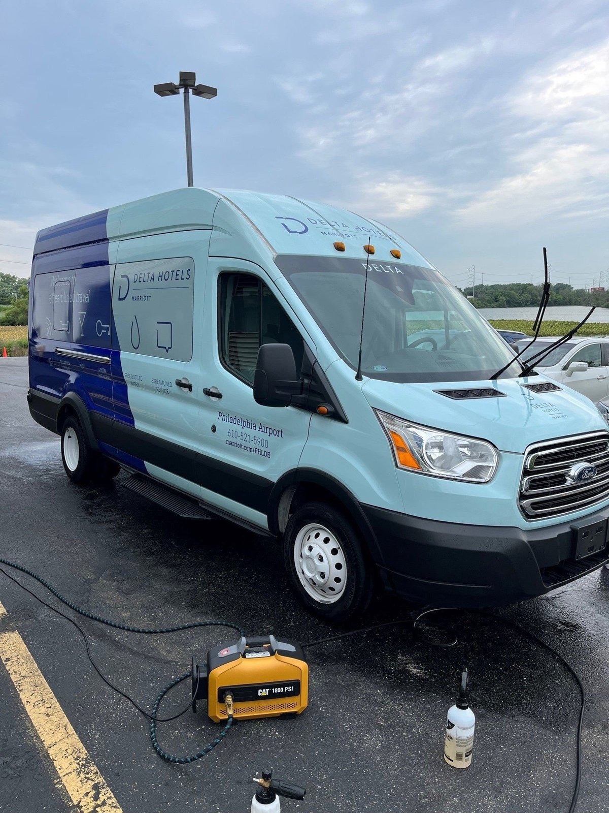 Light blue and dark blue Delta Hotels Marriott mobile hotel van detailed in a parking lot