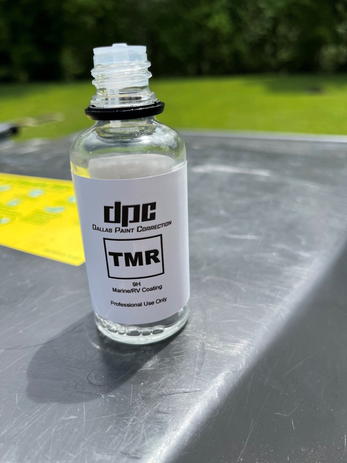 Bottle of ceramic paint coating displayed on a gray surface